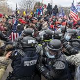 insurrectionists clashing with police on January 6th. Men are pushing against each other.